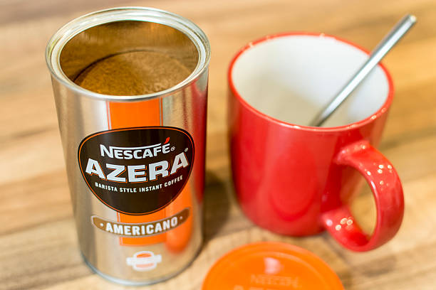 Poole, Reino Unido - Abril 1, 2016: A ton of Azera instant coffee from maker Nescafe with a mug and spoon. Barista Style Instant Coffee - Americano.