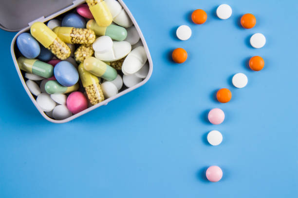 Tablets, pills and capsule in an aluminum box and in the form of a question mark.