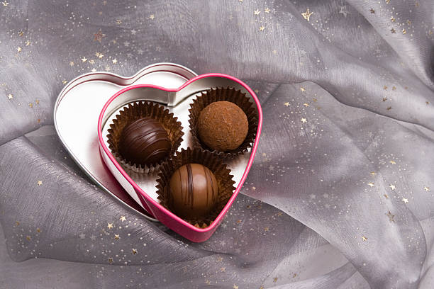 Three chocolates in a heart shaped tin