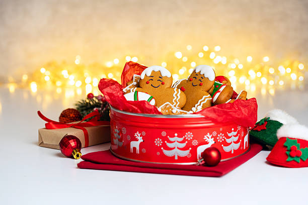Homemade Christmas Gingerbread cookies with festive decoration in a round red tin box.